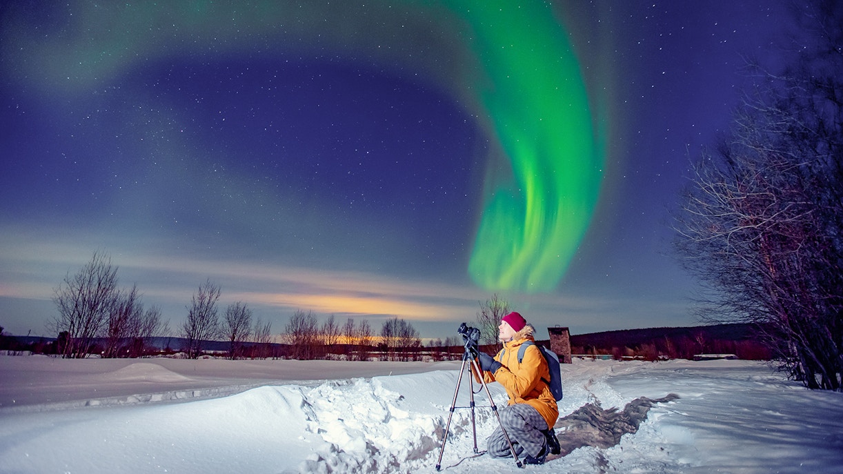 A male tourist enjoying photographing the northern lights
