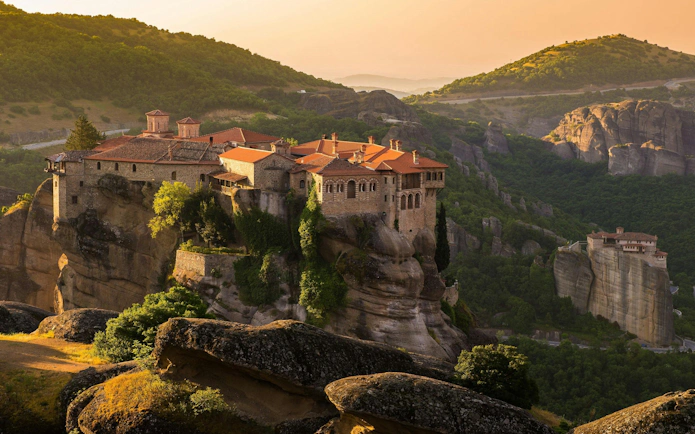 Monastery on rock formations at sunset, Meteora, Greece.