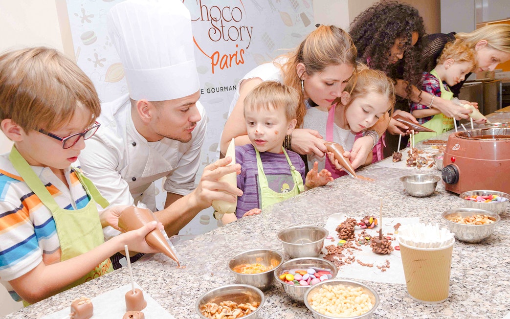 Children making chocolate treats with a chef at Choco-Story Paris.