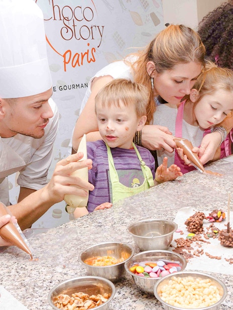 Children making chocolate treats with a chef at Choco-Story Paris.