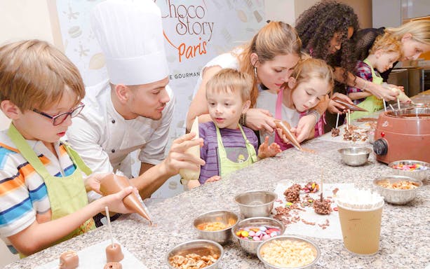 Chocolate chef guiding children in a hands-on workshop at Choco-Story Paris.