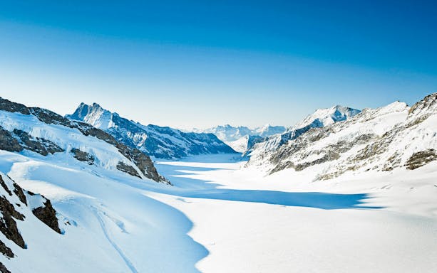 Snow-covered mountains and valleys in Interlaken, Switzerland, viewed from Schilthorn Cable Car.