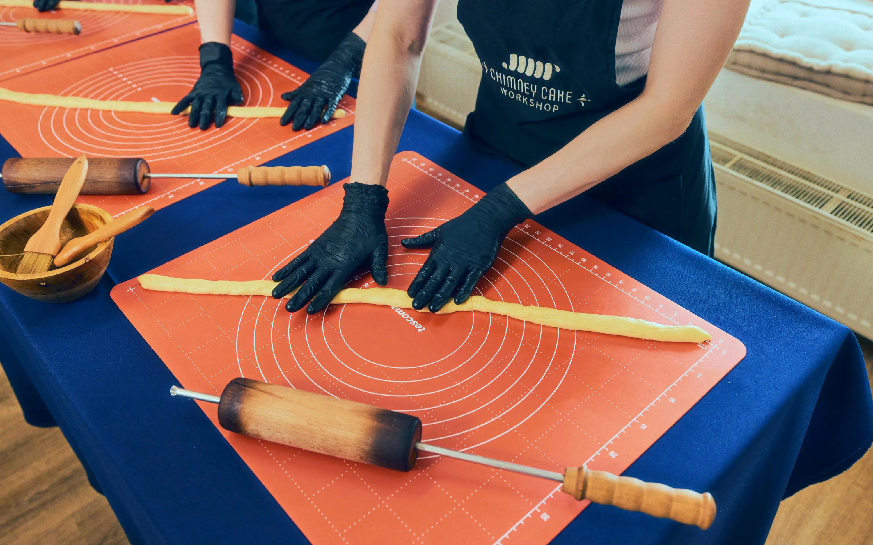Participants shaping dough at a Chimney Cake Workshop in Budapest.