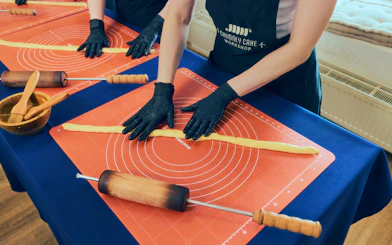 Participants shaping dough at a Chimney Cake Workshop in Budapest.