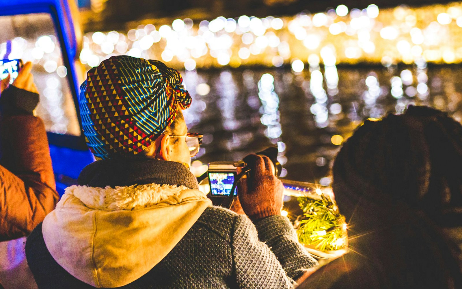 People enjoying Amsterdam Light Festival cruise with illuminated canal views.