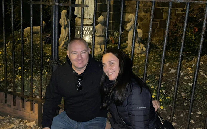 Couple at night near statues in Philadelphia during self-guided ghost tour.