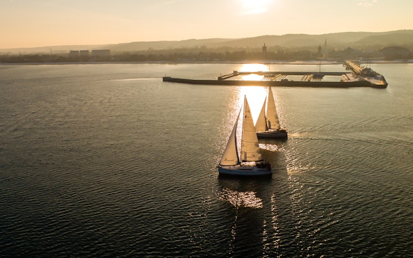Sailboats on a sunset cruise departing from Sopot Pier.
