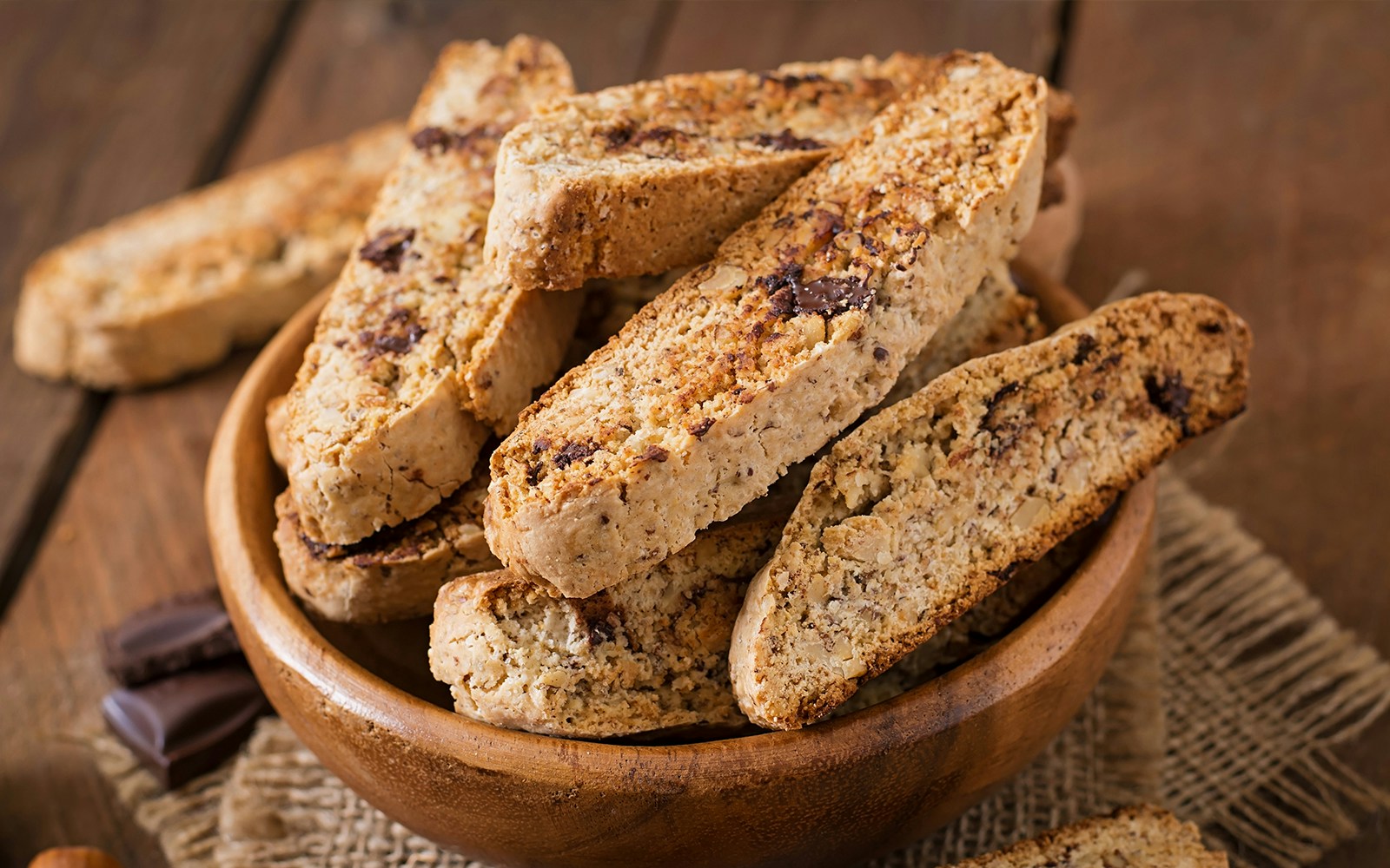 Biscotti displayed on a wooden table in an Italian café setting.