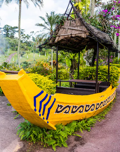 Yellow boat structure in South East Botanical Gardens surrounded by lush greenery.