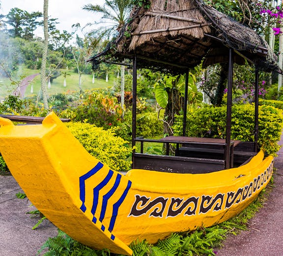 Yellow boat structure in South East Botanical Gardens surrounded by lush greenery.
