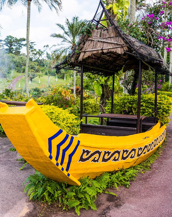 Yellow boat structure in South East Botanical Gardens surrounded by lush greenery.