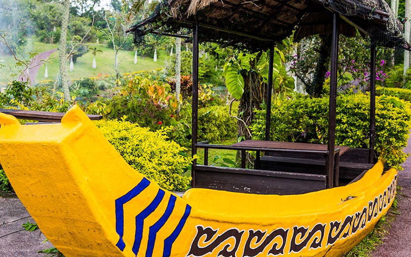 Yellow boat structure in South East Botanical Gardens surrounded by lush greenery.