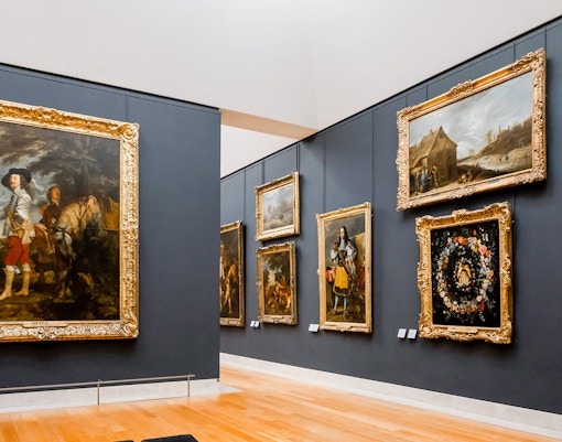 Tourists viewing paintings with direct access at the Louvre Museum in Paris