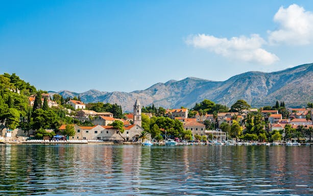 Cavtat waterfront with historic buildings and mountains in Croatia.