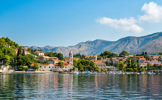 Cavtat waterfront with historic buildings and mountains in Croatia.