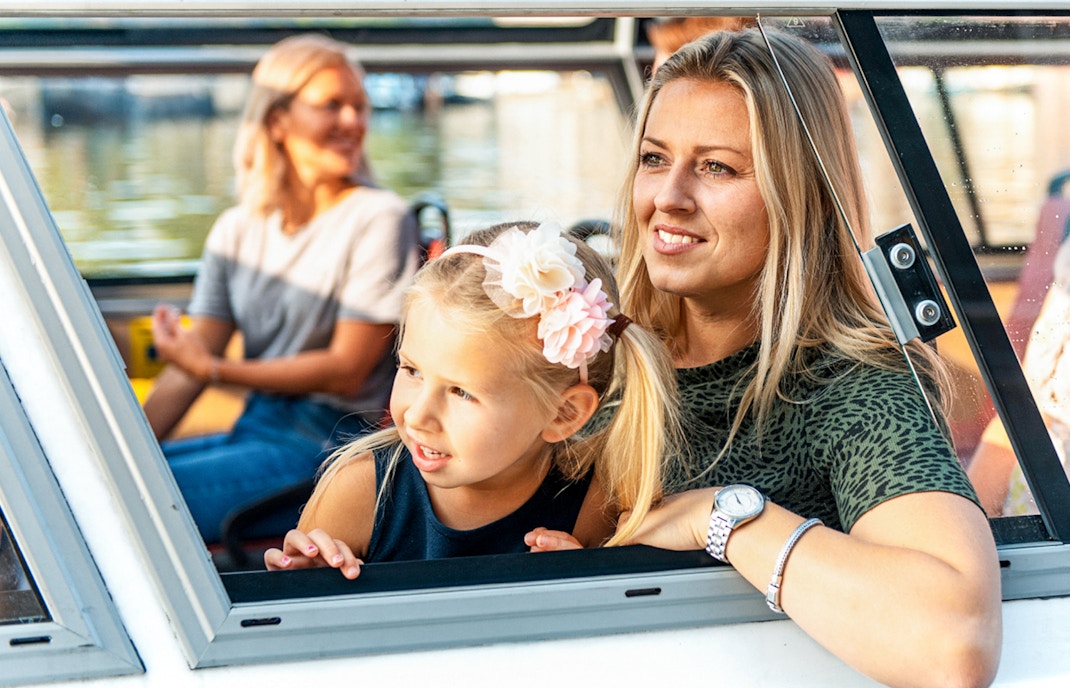 Mother and daughter enjoying Amsterdam city centre sightseeing cruise.