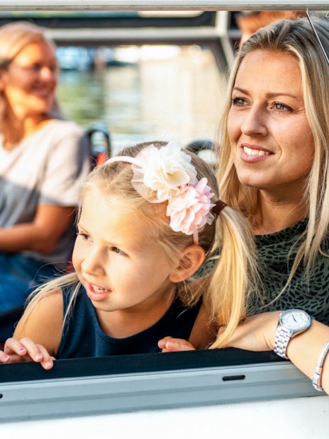 Mother and daughter enjoying Amsterdam city centre sightseeing cruise.