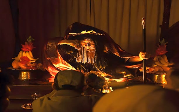 Mysterious figure in traditional attire during Hauntu experience, Malaysia.