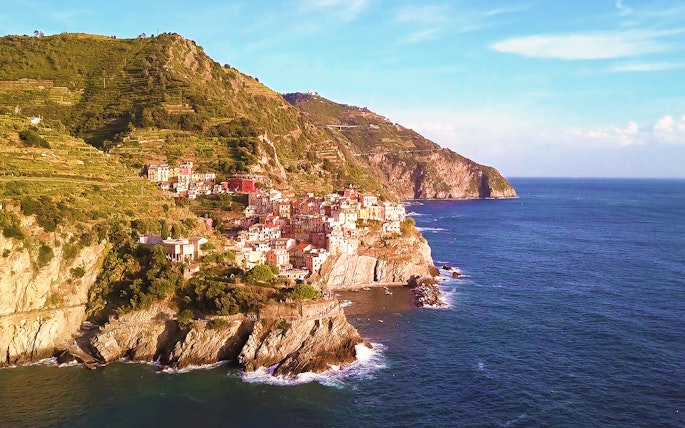 Cinque Terre coastal village view with colorful buildings on cliffs by the sea.