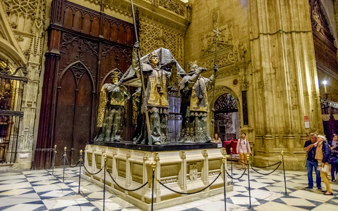Tomb of Columbus at Seville Cathedral, featuring ornate statues and Gothic architecture.
