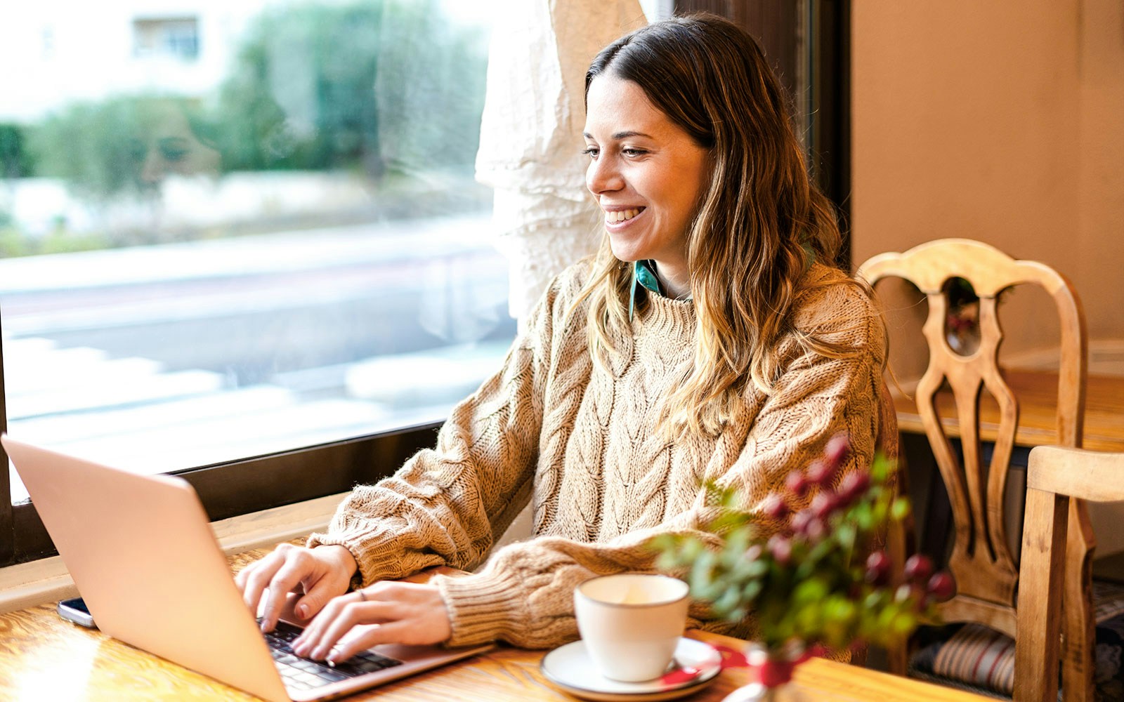Digital nomad working on a laptop in a cozy cafe.