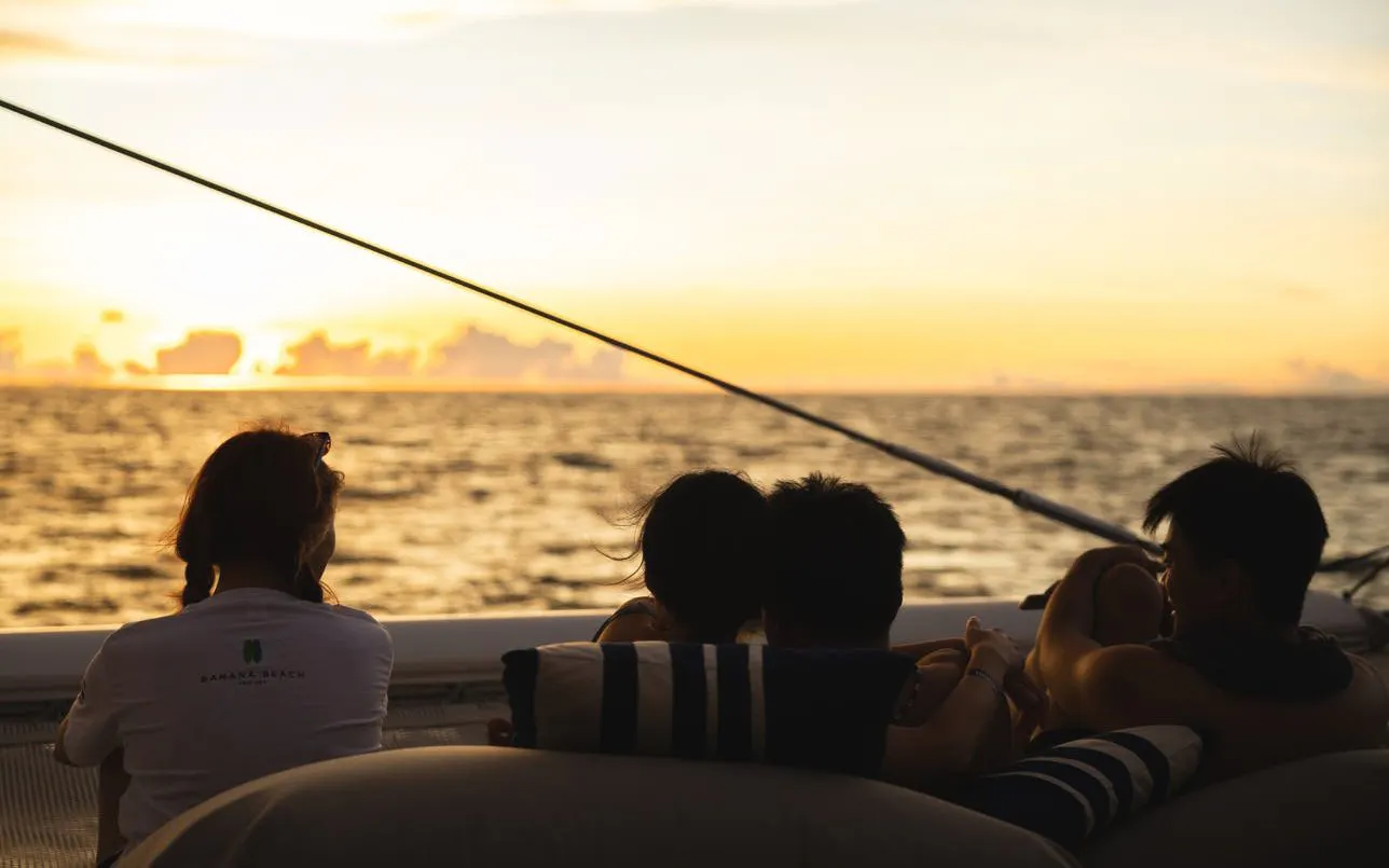 People relaxing on a catamaran at sunset, Ombre Yacht, Phuket.