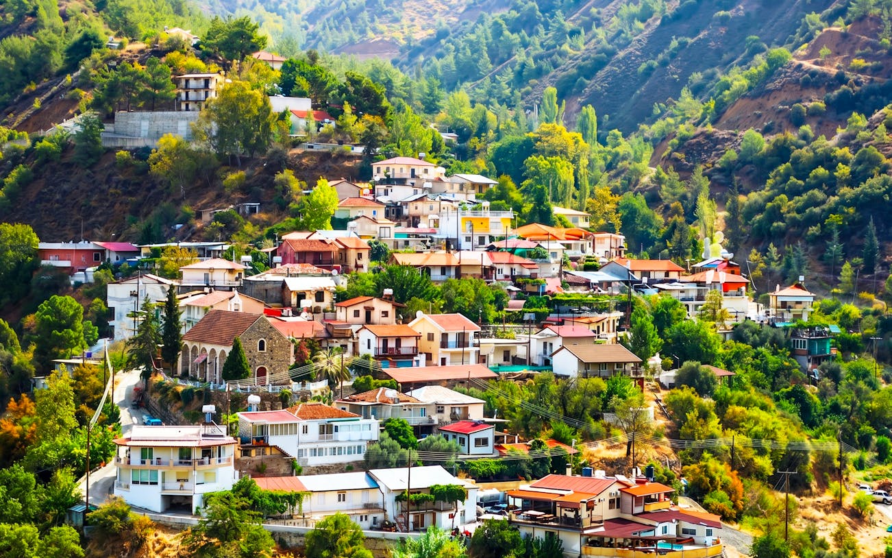 Troodos Mountains village with colorful houses surrounded by lush greenery, Cyprus.