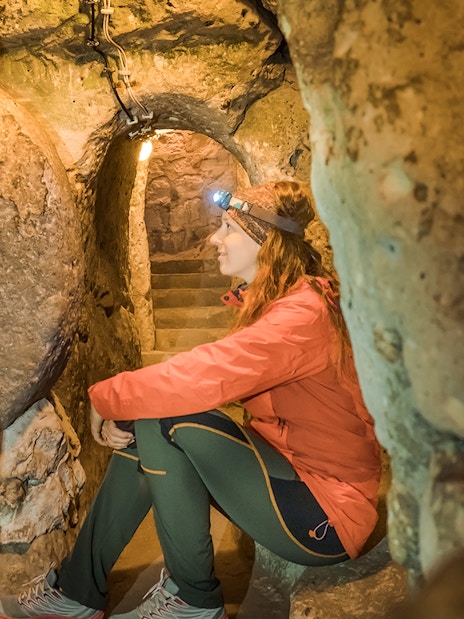 Young woman exploring Derinkuyu underground cave city in Turkey.