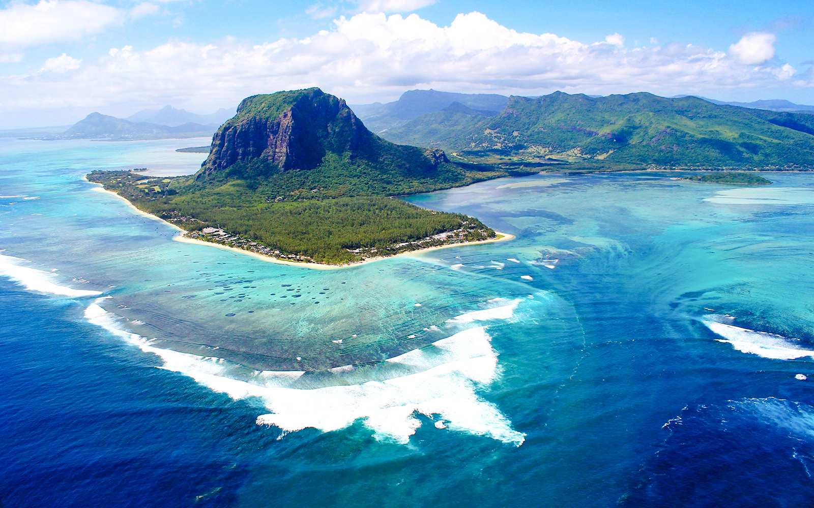 Aerial view of Le Morne Brabant mountain and turquoise waters in Mauritius during a seaplane tour.