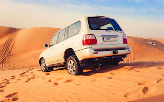 SUV driving on sand dunes during Dubai Desert Safari.