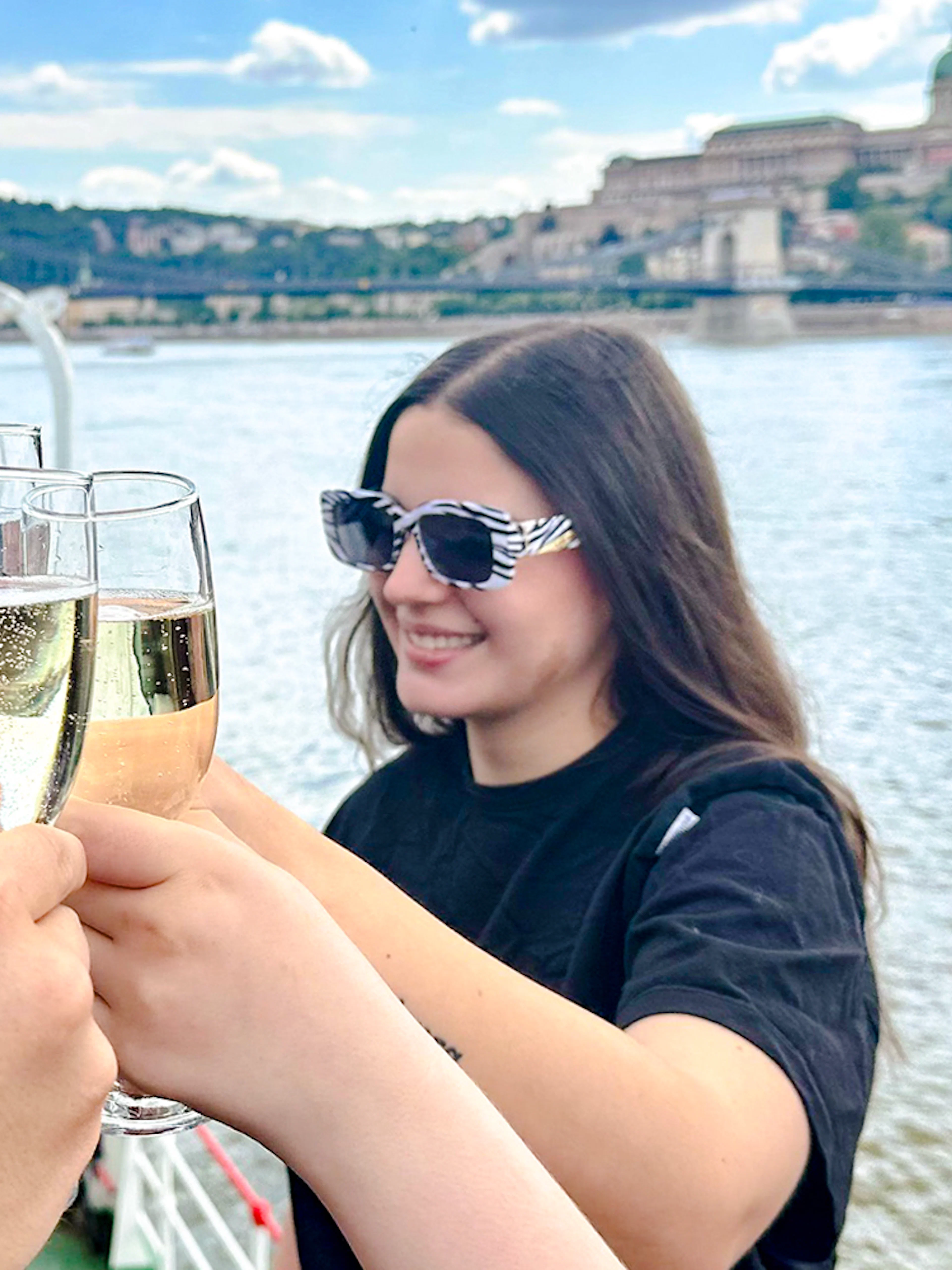Visitors toasting with champagne on a cruise along the Danube River, Budapest.