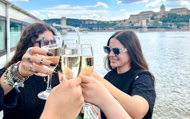 Visitors toasting with champagne on a cruise along the Danube River, Budapest.
