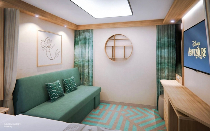 Deluxe Inside Stateroom on Disney Adventure Cruise with sofa, artwork, and TV.