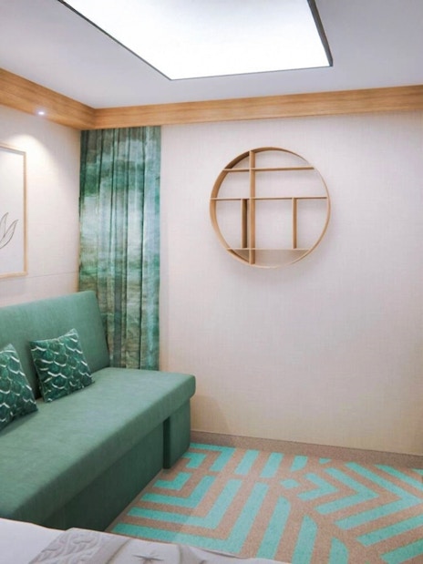 Deluxe Inside Stateroom on Disney Adventure Cruise with sofa, artwork, and TV.