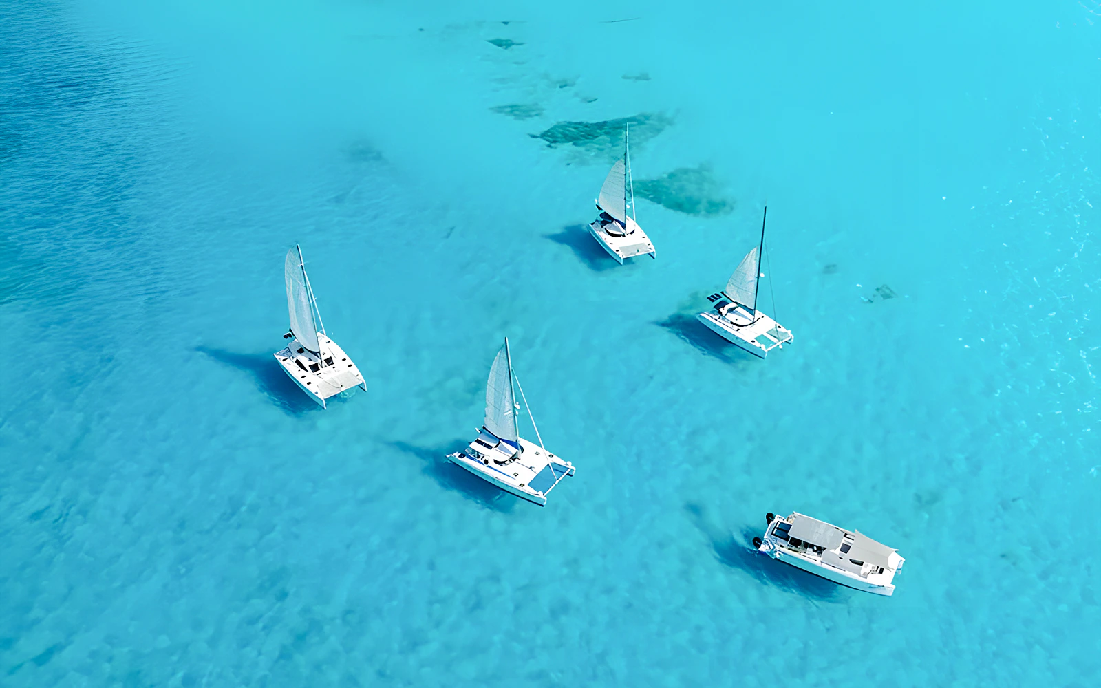 Catamarans sailing in clear blue waters of Isla Mujeres.