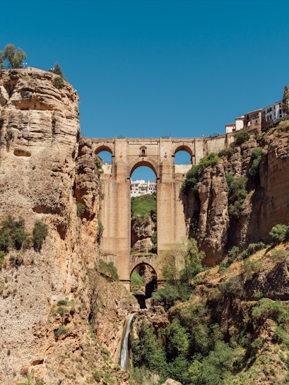 Puente Nuevo bridge spanning El Tajo Canyon with waterfall in Ronda, Malaga, Spain.
