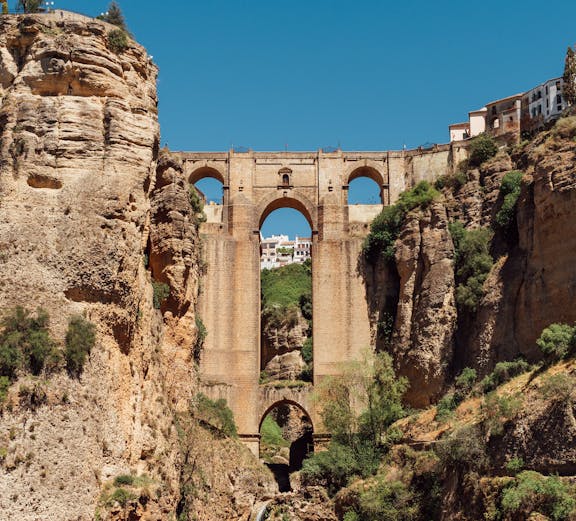 Puente Nuevo bridge spanning El Tajo Canyon with waterfall in Ronda, Malaga, Spain.