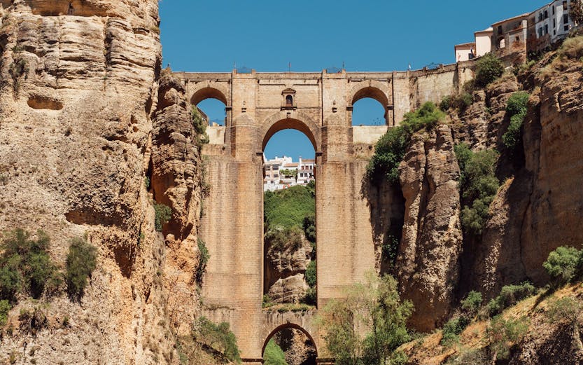 Puente Nuevo bridge spanning El Tajo Canyon with waterfall in Ronda, Malaga, Spain.