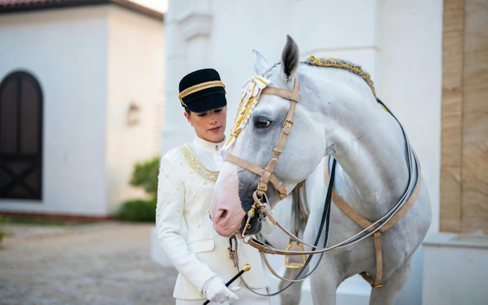 Equestrian guide with white horse at Abu Dhabi Royal Equestrian Arts tour.