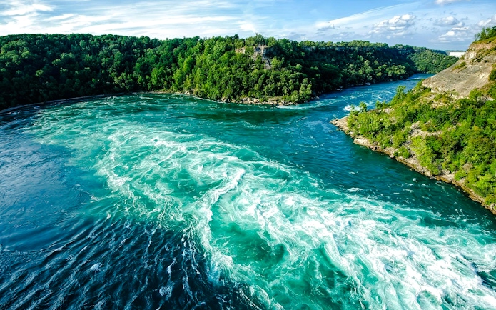 Niagara Falls State Park river view with surrounding lush greenery.