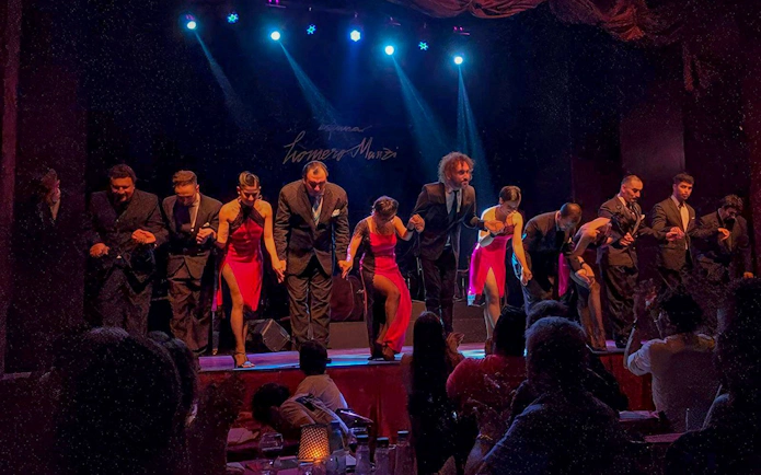 Performers bowing on stage at Homero Manzi Tango Show in Buenos Aires.