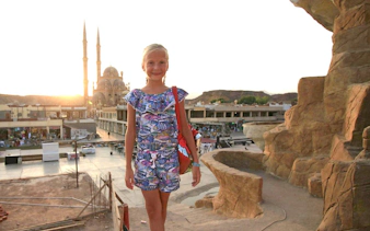 Child standing near mosque at sunset, Sharm El-Sheikh city tour.