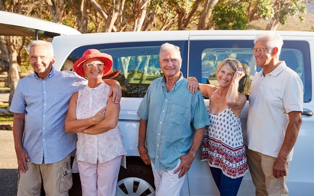 Senior travelers with guide on Tivoli day trip, standing by a tour van.