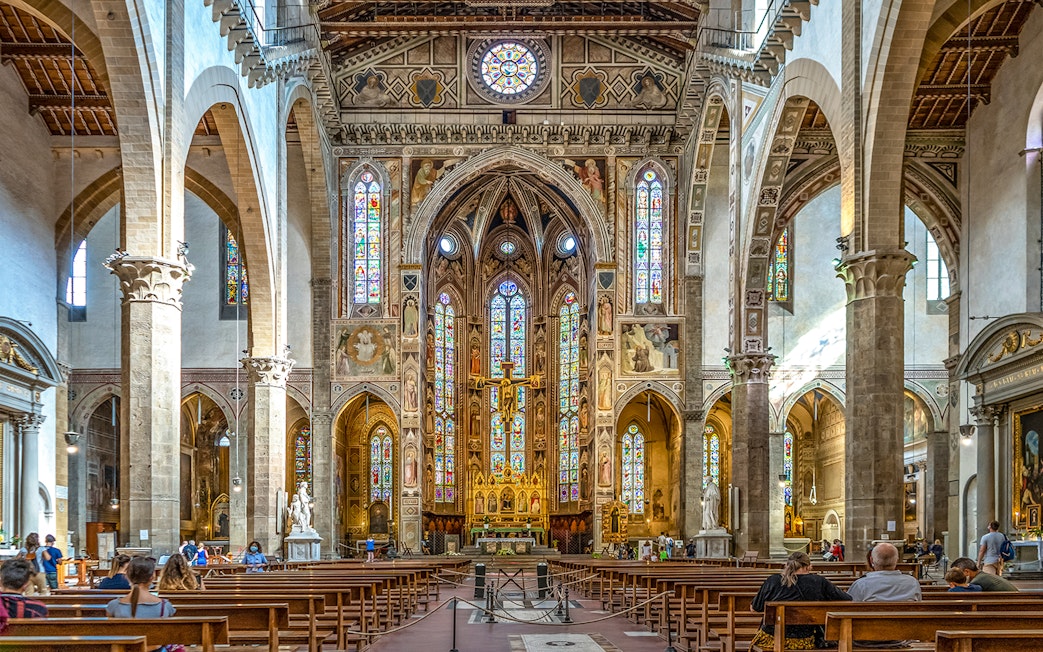 Santa Croce Basilica altar with stained glass windows and ornate architecture in Florence, Italy.