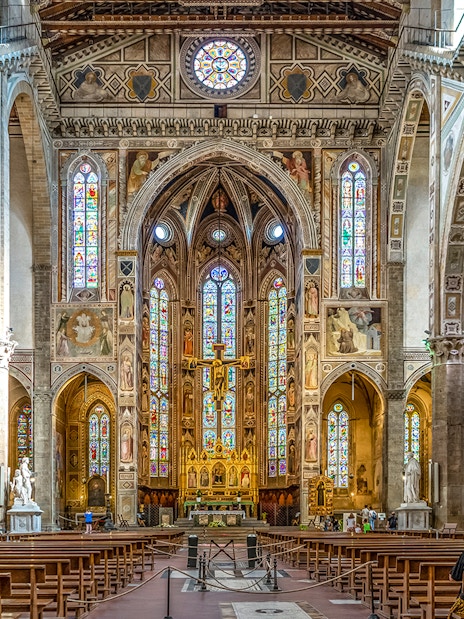 Santa Croce Basilica altar with stained glass windows and ornate architecture in Florence, Italy.