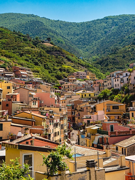 Colorful hillside village in Cinque Terre with church and terraced houses.