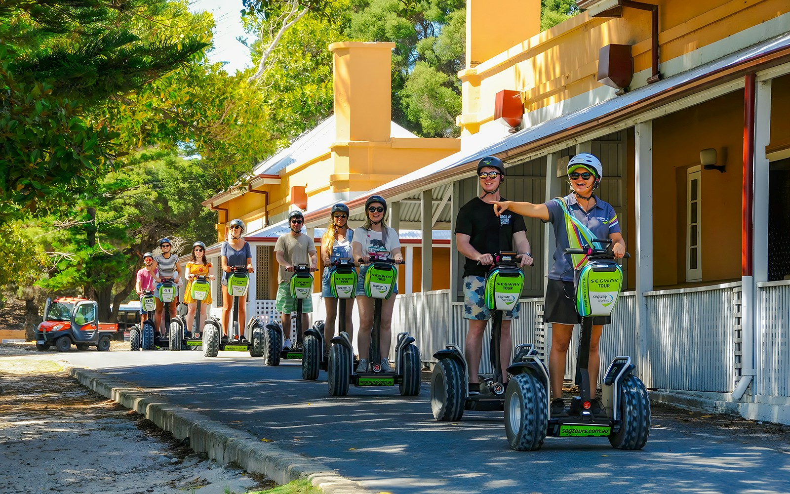 People on Segways during a tour on Rottnest Island, passing historic buildings.