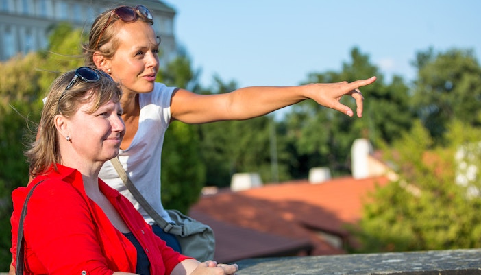 Guide pointing out directions to tourist during Arc de Triomphe walking tour.