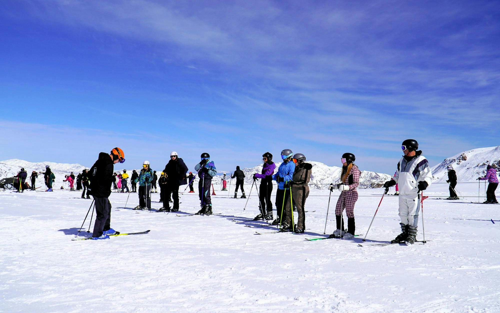 Skiers preparing on snowy slopes at Valle Nevado ski resort, Chile.