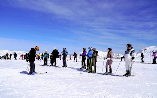 Skiers preparing on snowy slopes at Valle Nevado ski resort, Chile.